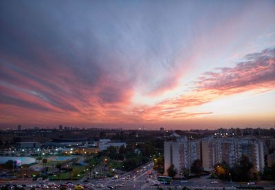 Illuminated cityscape against sky during sunset