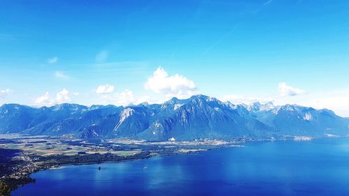 Scenic view of snowcapped mountains against blue sky