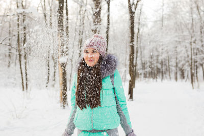 Portrait of smiling woman in snow covered forest