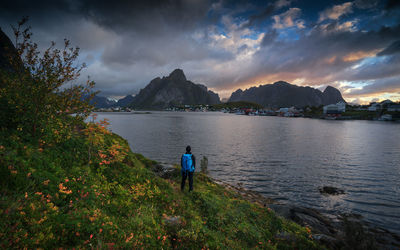 Man walking by sea against sky