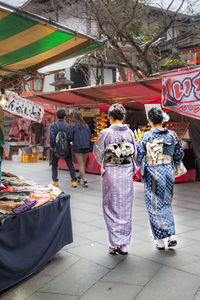 Rear view of women in kimonos at market