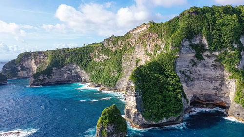 Nusa penida, indonesia. rocky area, covered with vegetation, washed turquoise sea. travel concept.