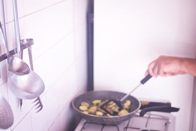 Cropped hand of person preparing food in kitchen