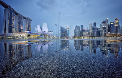 Reflection of modern buildings in city against sky