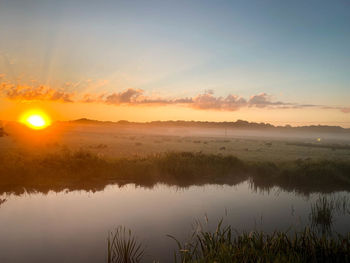 Scenic view of lake against sky during sunset