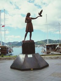 Woman standing by boat against sky