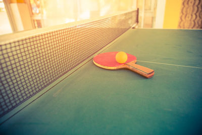 Close-up of racket and ball on tennis table