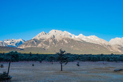 Scenic view of snowcapped mountains against clear blue sky