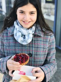 Portrait of smiling young woman holding fruit