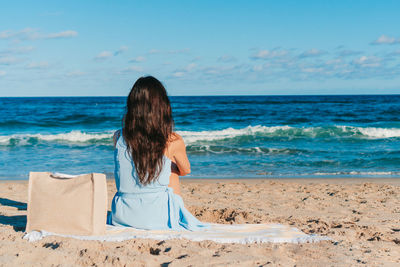 Rear view of woman standing at beach