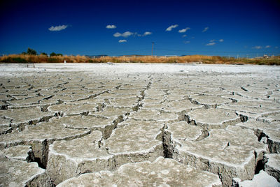 Scenic view of drought field against sky