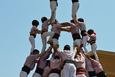 Low angle view of people dancing against sky