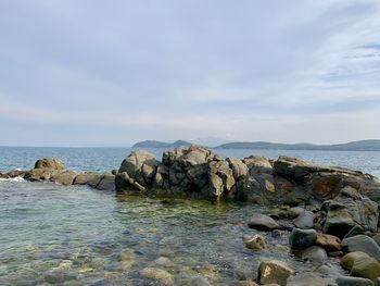 Rocks by sea against sky