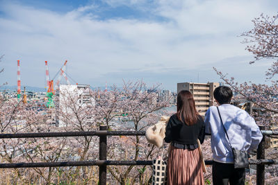 Pink cherry blossom with aratsu bridge and cityscape view with blur couple at spring, fukuoka