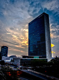 Low angle view of modern building against cloudy sky