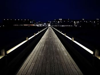 Illuminated bridge against sky at night