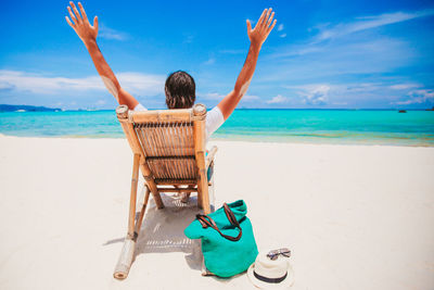 Rear view of person at beach against sky