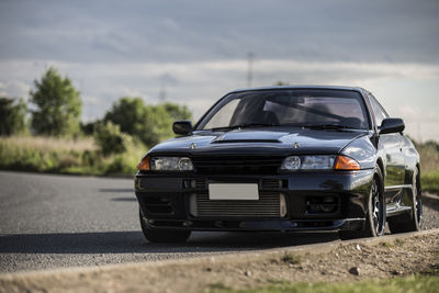 Black car on road against sky
