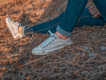 Low section of person wearing shoes on field