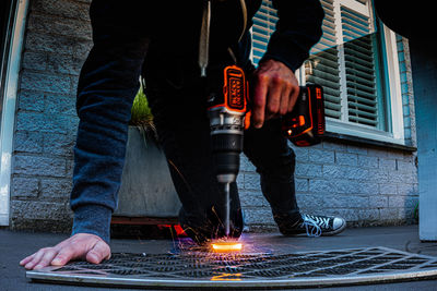 Low section of man drilling metal