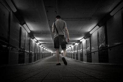 Rear view of man walking in corridor