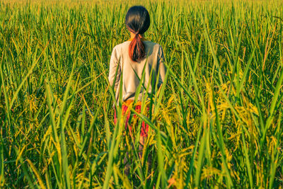 Rear view of woman standing in field