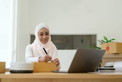 Young woman using laptop at office