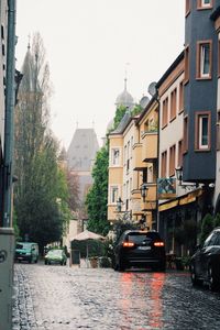 Cars on street in city against clear sky