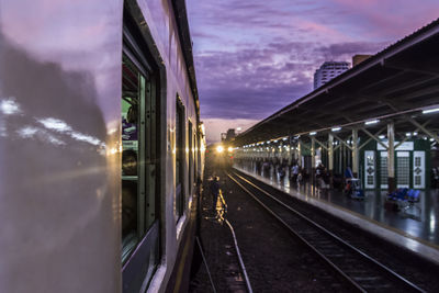 Train at railroad station against sky during sunset