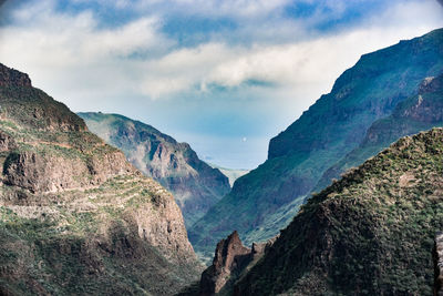 Scenic view of mountains against cloudy sky