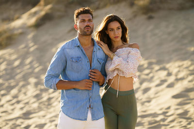 Portrait of young couple standing on beach