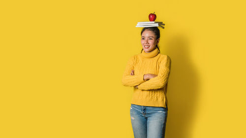 Portrait of smiling man standing against yellow background