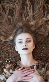 Portrait of smiling young woman lying on field