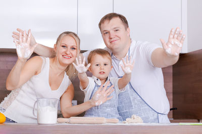 Father mother and son at home stand at the table in the kitchen together