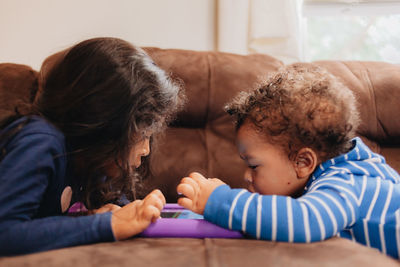 Cute kids playing on sofa at home