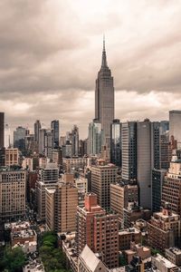 View of cityscape against cloudy sky