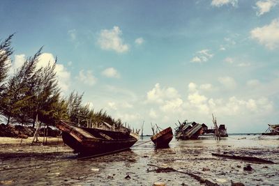 Boats moored on sea shore against sky