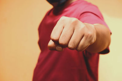 Close-up of man hand on red wall