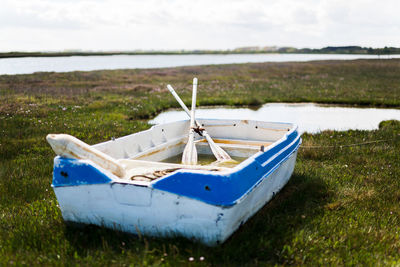 Boat moored on shore against sky