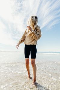 Low angle view of woman standing at beach
