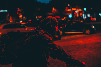 Man standing on city street at night