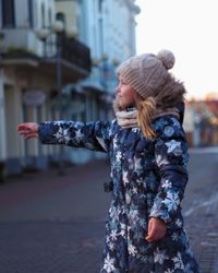 Woman standing on street against city in background