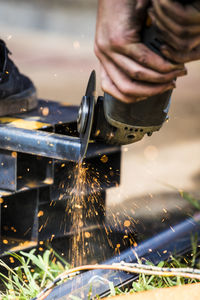 Close-up of skilled worker using angle grinder to cut steel.