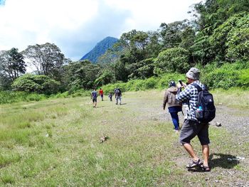 Rear view of people walking on land