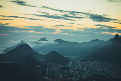 Aerial view of townscape and mountains against sky
