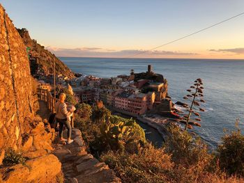 High angle view of woman standing on cliff against sea