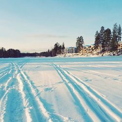 Snow covered landscape against blue sky