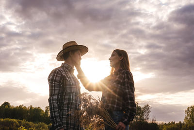 Friends standing against sky during sunset