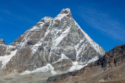 Scenic view of snowcapped mountain against blue sky