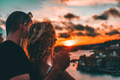 Midsection of couple against sky during sunset